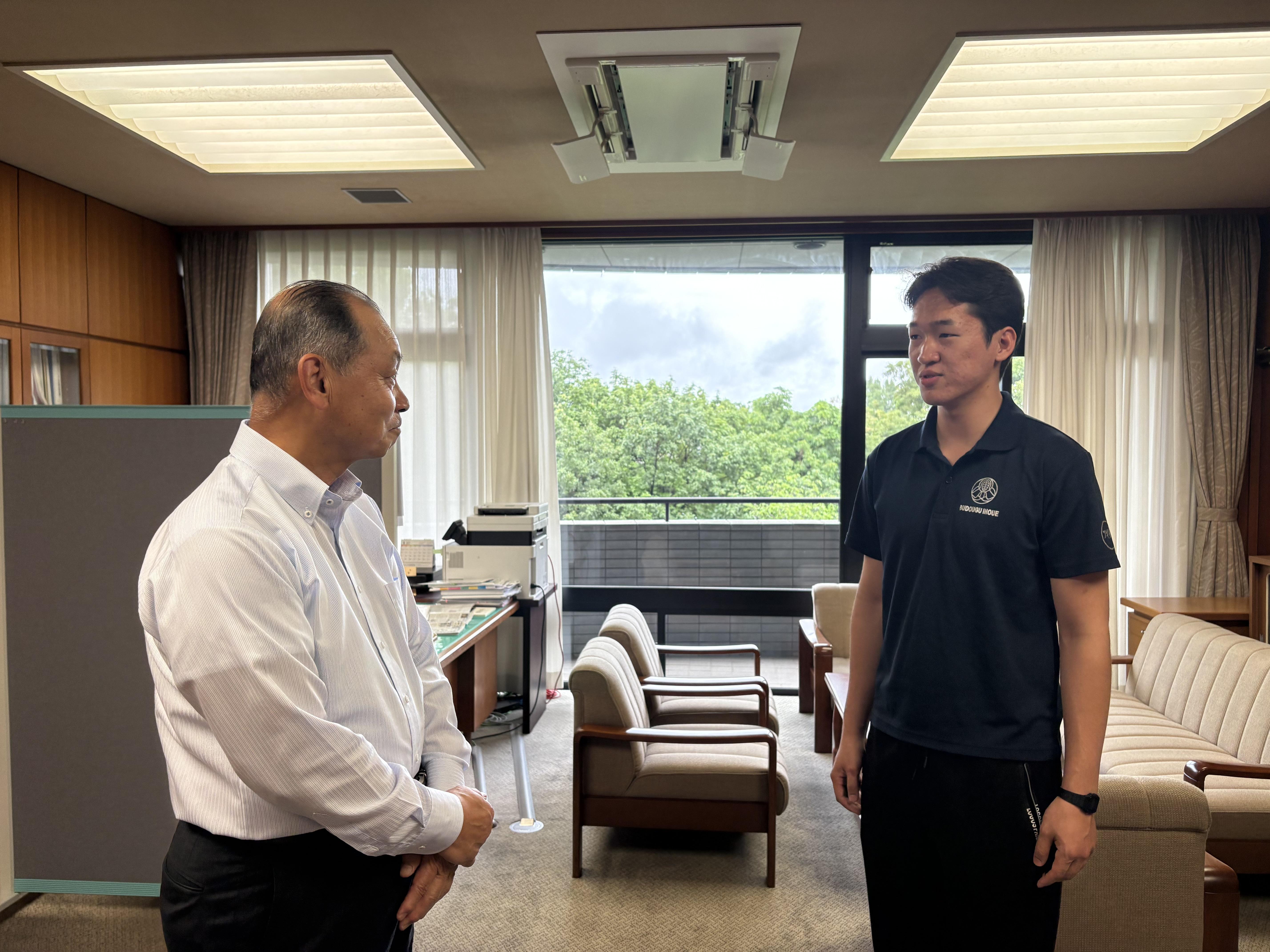表敬訪問にて、日野伸一学長へこれまでの稽古の歩みと大会での目標を報告する交通機械工学科3年のイヘバヤルさん