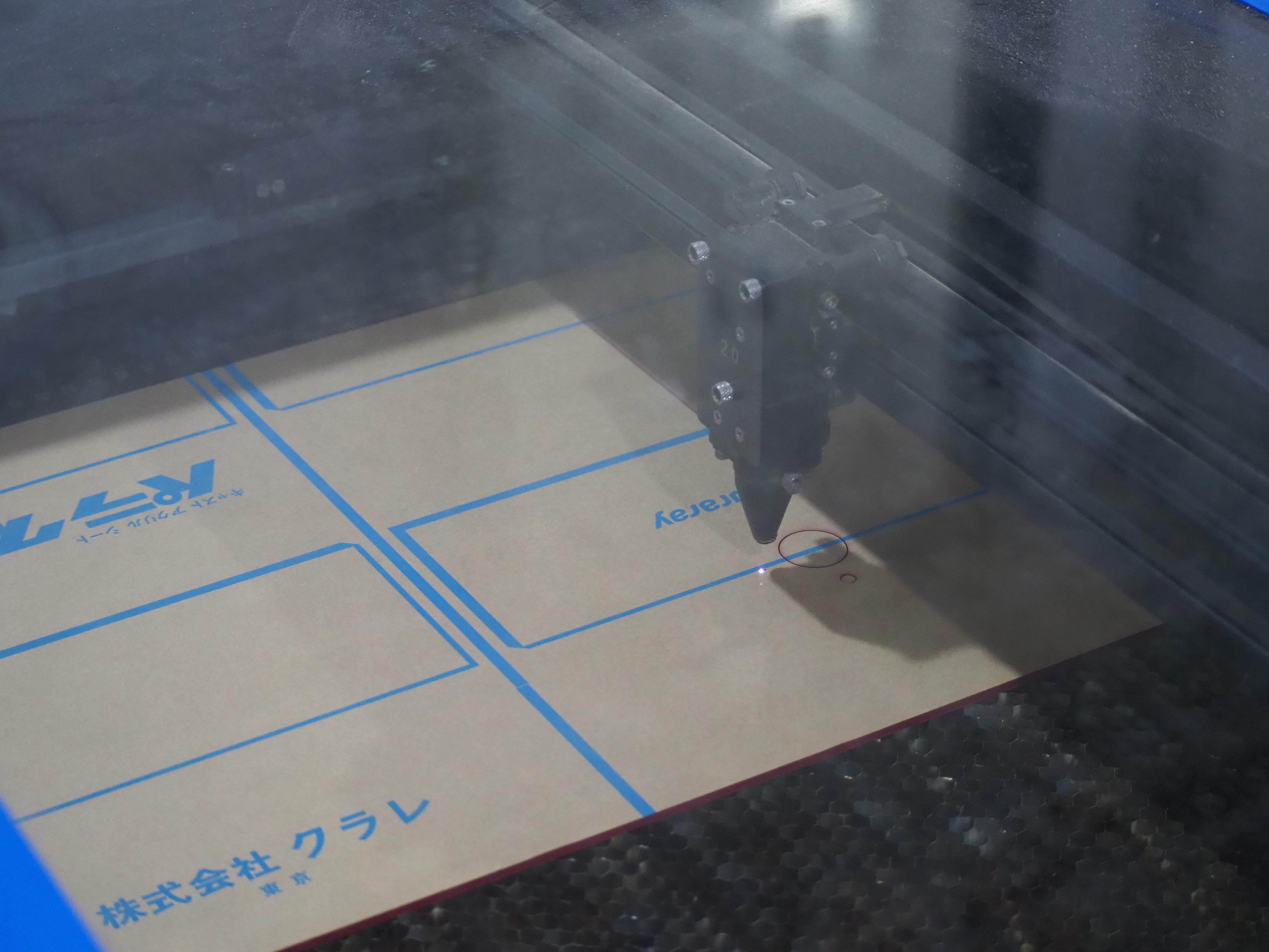 青いフィラメント（素材）を使用し、3Dプリンターで展示物用の細かな試作部品を立体的に造形している様子。