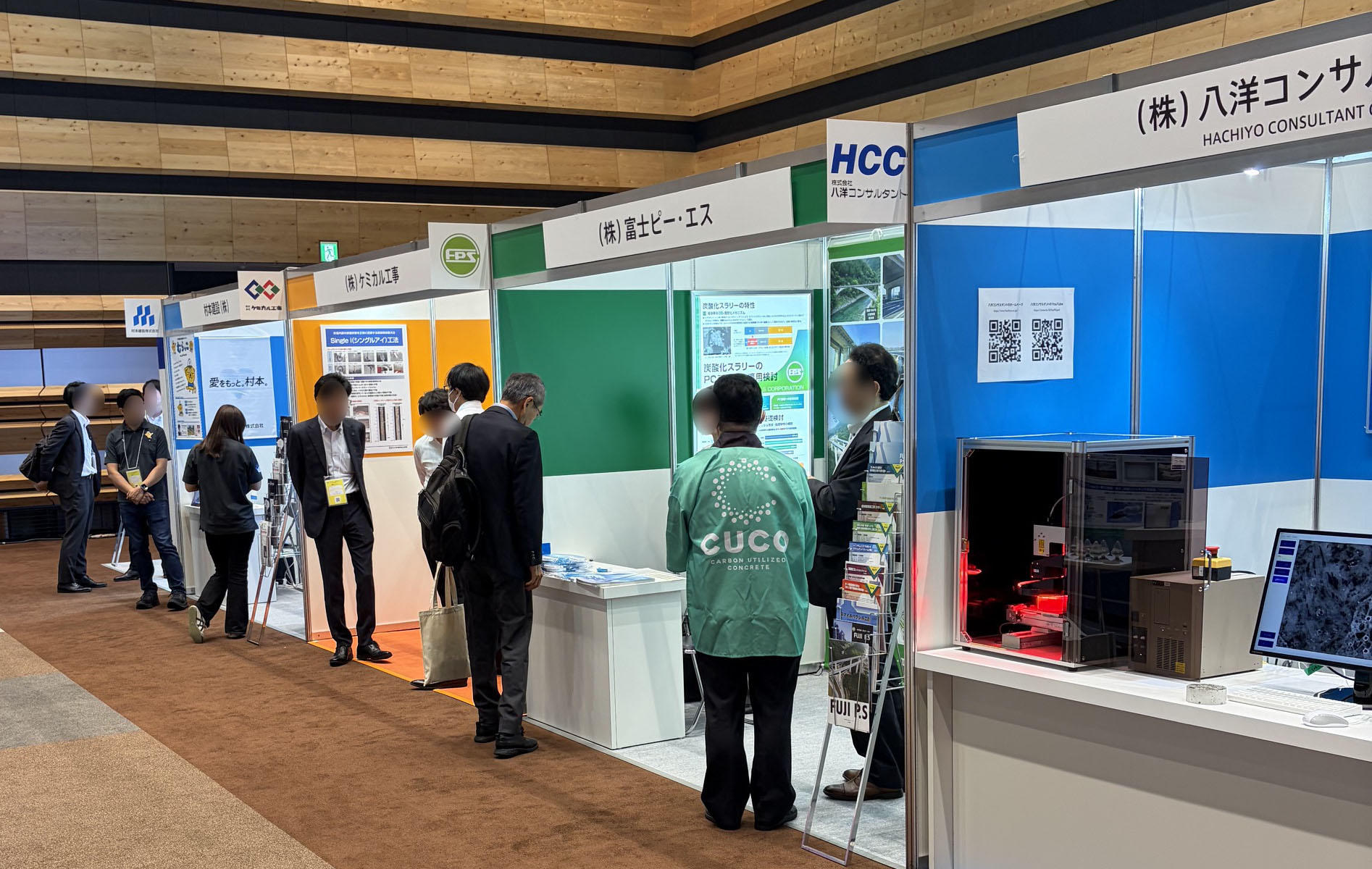 各企業の展示ブースやポスターが並び、多くの参加者でにぎわう展示会場の様子